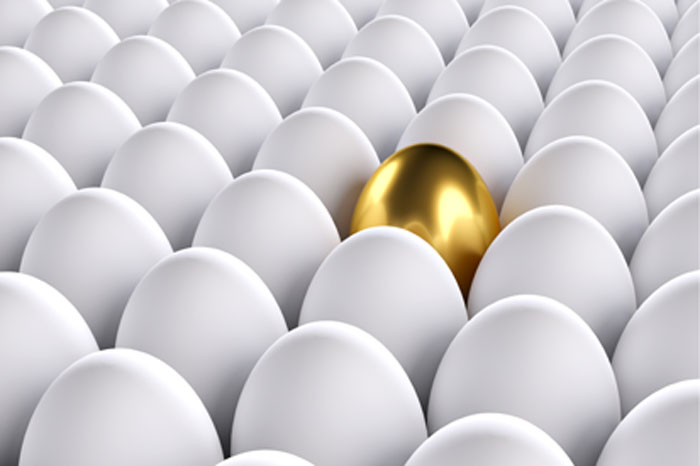 Kennen Sie Ihr Risiko bei der Krebsvorsorge? Auffälligkeiten werden bei der Vorsorge oft übersehen. Eine schonende Behandlung ist dann meist nicht mehr möglich. Weiße Hühnereier in einer Stiege, in der Mitte ein goldes Ei.